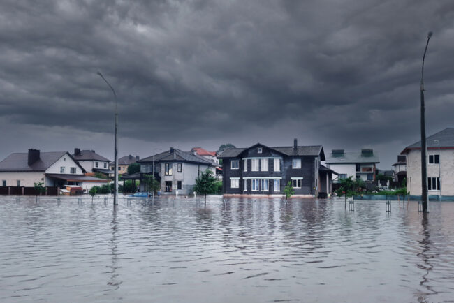 Extreme heavy rain storm weather. Flooded streets of the neighborhood. A flooded road junction with a drowned house. Heavy rains from tropical storm caused many flooded areas. Rains caused many floods Portable Mobile Towers Ready for Hurricane Season