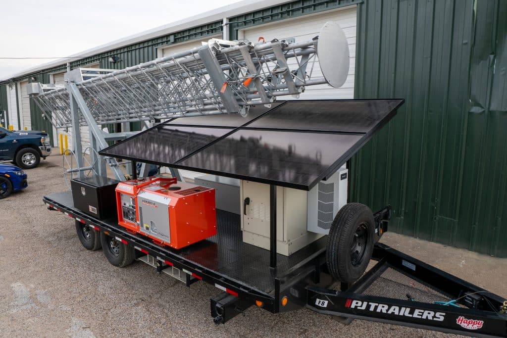 Hybrid power telecom tower from Solaris Technologies Services combining solar panels, shore power, and generator backup for reliable mobile connectivity.